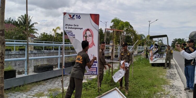 FOTO: RZL/MATAKALTENG - Personel Satpol PP Kota Palangka Raya, pada saat membersihkan APK di Jalan Bukit Keminting.