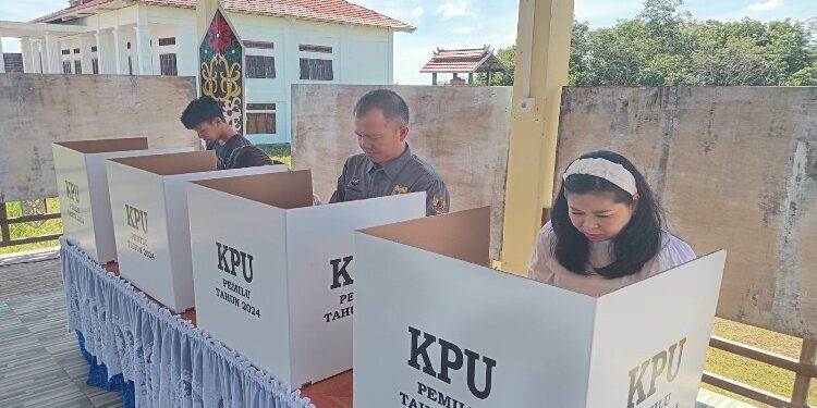 FOTO : DISKOMINFO SANTIK/MATA KALTENG - Bupati Gumas Jaya S Monong bersama istri ketika melakukan pencoblosan pada bilik suara pada TPS 13, Kelurahan Tampang Tumbang Anjir, Kecamatan Kurun, Rabu, 14 Februari 2024.