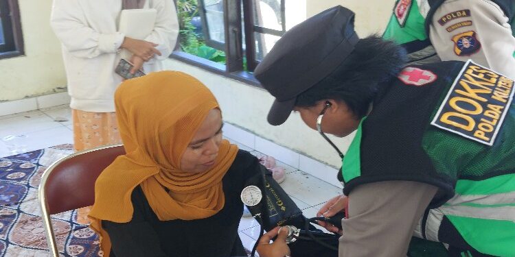 FOTO: RZL/MATAKALTENG - Ketua KPPS Kelurahan Panarung, Binti Masruroh, pada saat dilakukan pemeriksaan kesehatan oleh personel Biddokkes Polda Kalteng.
