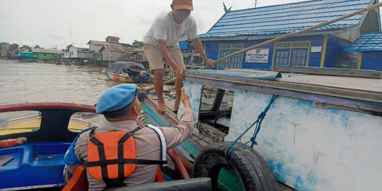 FOTO: MATAKALTENG - Anggota polsek Jenamas saat memeriksa salah satu kapal yang melintas sungai DAS Barito.