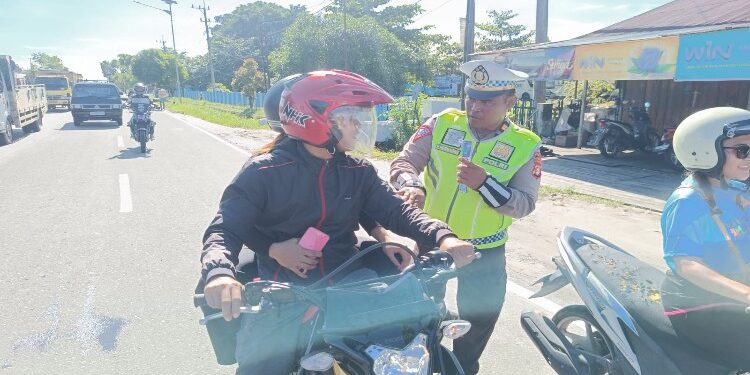 FOTO: RZL/MATAKALTENG - Kanit Kamsel Satlantas Polresta Palangka Raya, Iptu Eko Hermawan, saat mengedukasi pengendara yang melintas di Jalan Tjilik Riwut kilometer 7, Kota Palangka Raya.