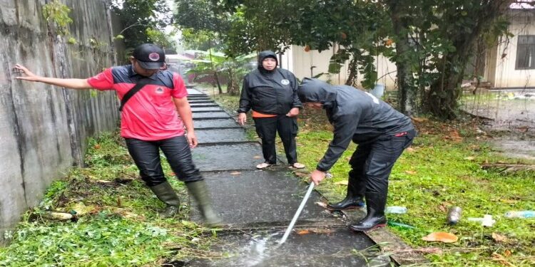 FOTO: MATAKALTENG - Tim BPBD Kota Palangka Raya, pada saat melakukan penanganan terhadap saluran drainase yang meluap.