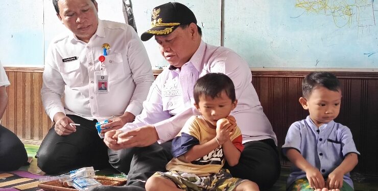 FOTO : DOK DEVIANA/MATAKALTENG - Bupati Kotim Halikinnor didampingi Sekretaris Daerah Fajrurrahman saat membagikan susu dan telur pada anak, beberapa waktu lalu. 