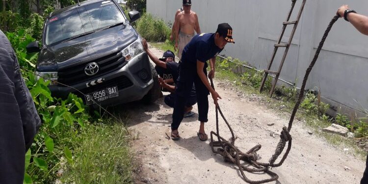 FOTO: MATAKALTENG - Tim Rescue DPKP Palangka Raya saat membantu mengeluarkan mobil Toyota Hilux dari parit.