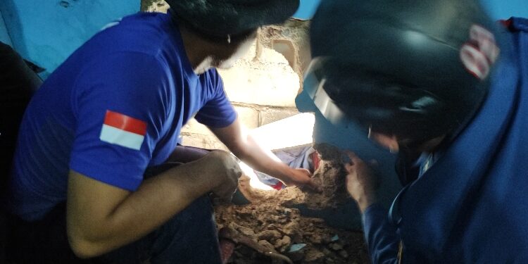 FOTO: IST/MATAKALTENG - Proses penyelamatan yang di lakukan Tim Rescue Disdamkarmat Kotim, menjebol tembok rumah korban untuk proses evakuasi.
