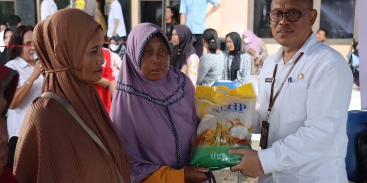 FOTO: PROKOM SERUYAN/MATA KALTENG - Pj Sekda Seruyan, Bahrun Abbas (kanan) saat menyerahkan paket beras dalam program GPM di Halaman Kantor DKPP setempat, kemarin.