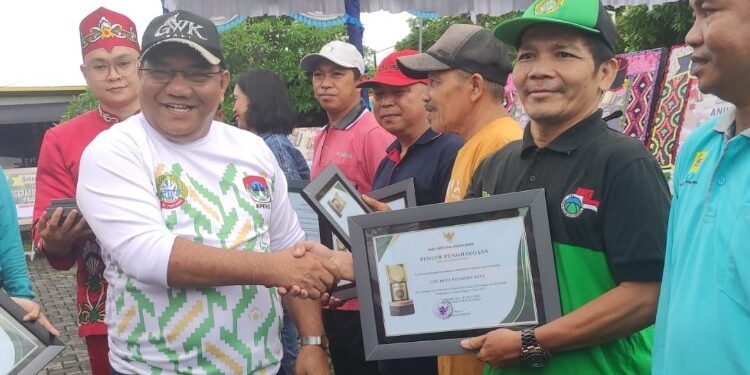FOTO: MATAKALTENG - Sekretaris DPD LDII Palangka Raya Rudy Totok Purnomo saat menerima piagam penghargaan di kawasan sentra kuliner.