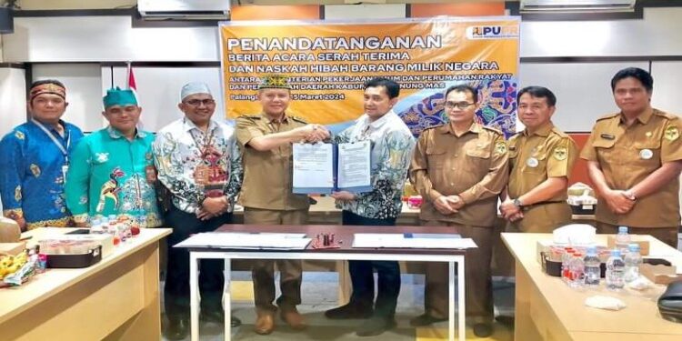 FOTO: MATAKALTENG - Bupati Gumas Jaya S Monong bersama Kepala Balai Prasarana Permukiman Wilayah Kalteng Ade Syaiful Rachman, ketika menunjukkan naskah dan berita acara serah terima hibah barang milik negara yang sudah ditandatangani, pekan lalu.