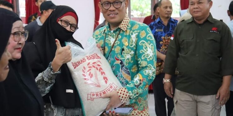 FOTO: PROKOM SERUYAN/MATA KALTENG - Pj Sekda Seruyan, Bahrun Abbas saat menyerahkan secara simbolis paket bantuan beras dalam agenda Pasar Murah yang dilaksanakan oleh Pemprov Kalteng di Gedung Serbaguna Kuala Pembuang, Jum'at 22 Maret 2023.