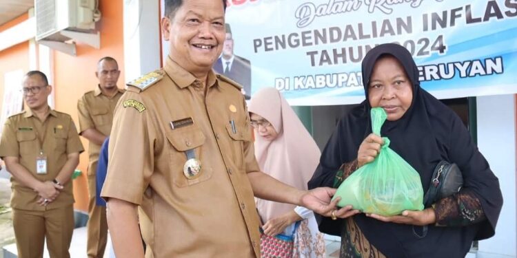 FOTO: PROKOM SERUYAN/MATA KALTENG - Pj Bupati Seruyan, Djainuddin Noor (kiri) saat menyerahkan secara simbolis paket sembako dalam agenda Pasar Murah di Kantor Kelurahan KP II, Senin 25 Maret 2024.