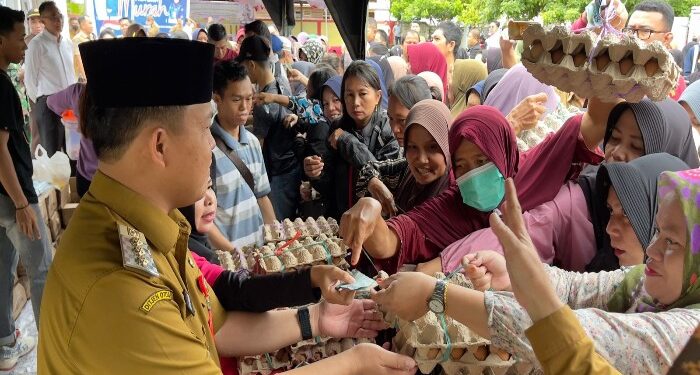 FOTO: MATAKALTENG - Pj Bupati Barsel, Deddy Winarwan, saat melayani masyarakat yang membeli pangan murah.