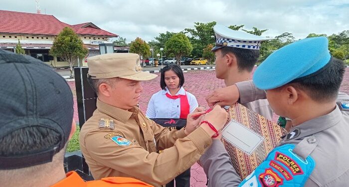 FOTO : SID/MATA KALTENG - Bupati Gumas Jaya S Monong ketika menyematkan pita kepada perwakilan apel gelar pasukan operasi ketupat tahun 2024, di halaman mapolres setempat, Rabu, 3 April 2024.
