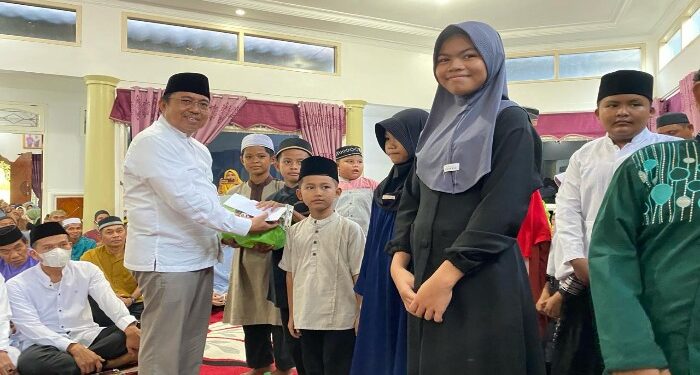 FOTO: AKH/MATAKALTENG - Pj Bupati Sukamara Kaspinor saat menyerahkan bingkisan kepada anak-anak yang hadir di rumah jabatan Bupati Sukamara.