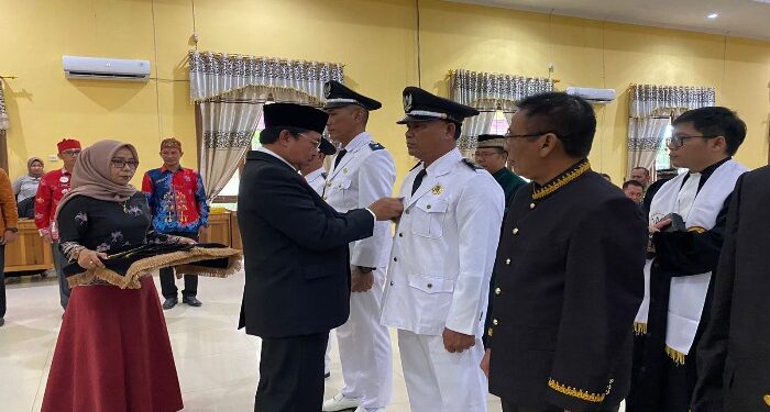Foto : AKH/MATAKALTENG - Pj Bupati Sukamara Kaspinor saat menyematkan pin Pj Kepala Desa yang baru dilantik.