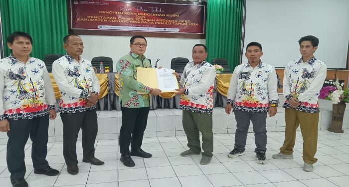 FOTO : KPU GUMAS/MATA KALTENG - Ketua KPU Kabupaten Gumas Elfrinst G Tumon didampingi empat komisioner KPU, menyerahkan salinan surat keputusan penetapan perolehan kursi dan calon terpilih anggota DPRD pemilu pada tahun 2024 kepada Ketua Bawaslu Yepta H Jinal, di aula kantor bapperida, Kamis (2/5) sore.