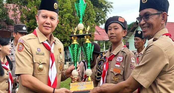 FOTO : DISKOMINFO SANTIK/MATA KALTENG - Bupati Gumas Jaya S Monong didampingi Ketua Gerakan Pramuka Kwarcab Gumas Mimie Mariatie Jaya S Monong, ketika menyerahkan piala kepada para pemenang LGP tingkat kabupaten, di Lapangan SMPN 3 Tewah, Minggu, 5 Mei 2024.