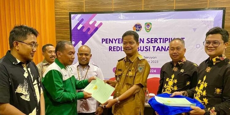 FOTO: PROKOM SERUYAN/MATA KALTENG - Pj Bupati Seruyan, Djainuddin Noor (tiga dari kanan) saat menyerahkan secara simbolis sertifikat redistribusi tanah di Sampit, Rabu 8 Mei 2024.