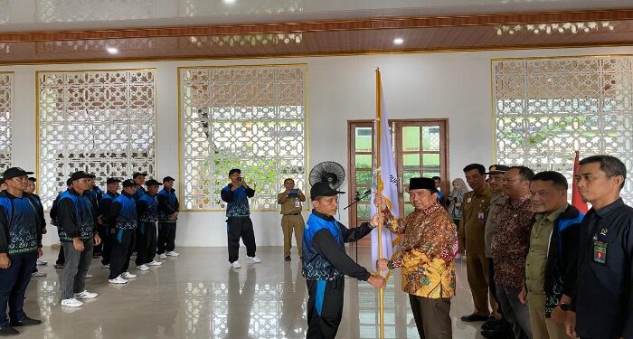 Foto : AKH/MATAKALTENG - Pj Bupati Sukamara Kaspinor saat menyerahkan bendera Gawi Barinjam kepada Ketua Kontingen FBIM Kabupaten Sukamara.