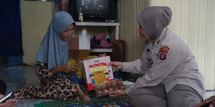 FOTO: MATAKALTENG - Personel Rumkit Bhayangkara Tingkat III Palangka Raya, pada saat menyerahkan telur kepada warga.