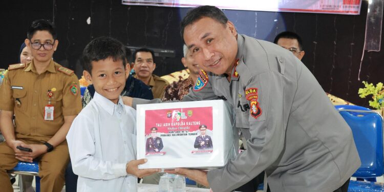 FOTO: MATAKALTENG - Dirbinmas Polda Kalteng, Kombes Pol Ebet, pada saat menyerahkan secara simbolis bantuan kepada salah seorang anak di LKSA Kasih Karunia.