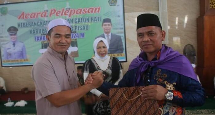 FOTO : IST/MATAKALTENG - Ketua DPRD Pulang Pisau, H Ahmad Rifa'i saat memberikan bingkisan kepada jama'ah haji Pulpis.