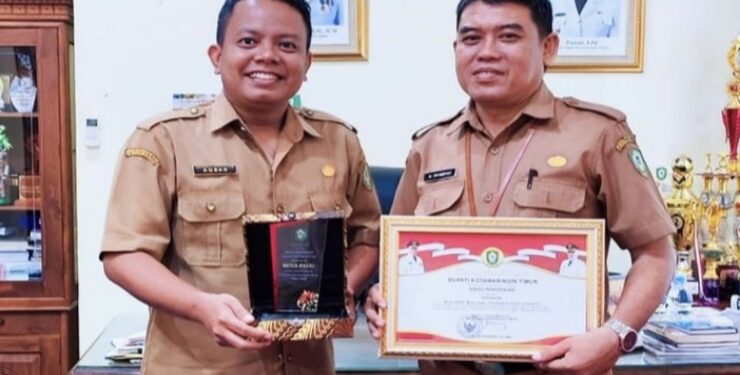 FOTO : DISDIK/MATA KALTENG - Kepala Disdik Kotim M Irfansyah (kanan) dan Kasi Kurikulum Muhammad Noor Aqbar saat menunjukkan penghargaan dari Bupati Kotim.