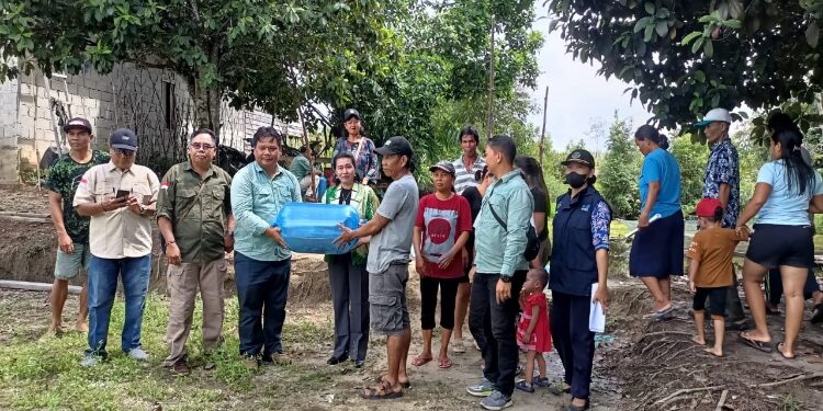 FOTO : DPRD GUMAS/MATA KALTENG - Anggota DPRD Kabupaten Gumas Rayaniatie Djangkan bersama dinas terkait, saat menyalurkan bibit dan pakan ikan ke kelompok pembudidaya ikan, di Desa Pilang Munduk, Senin 3 Juni 2024.