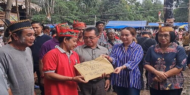 FOTO : DPRD GUMAS/MATA KALTENG - Anggota DPRD Kabupaten Gumas Nomi Aprilia (baju biru) ketika menyerahkan bantuan kepada panitia tiwah massal di Kelurahan Tampang Tumbang Anjir, Kecamatan Kurun, Minggu 9 Juni 2024.