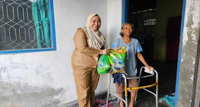 FOTO: MATAKALTENG - Lurah Panarung, Evi Kahayanti, pada saat memberikan bantuan kepada salah seorang warga.