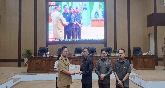 FOTO: MATAKALTENG - Pj Bupati Katingan Saiful, saat menyerahkan Raperda RPJPD kepada Ketua DPRD Katingan Marwan Susanto.