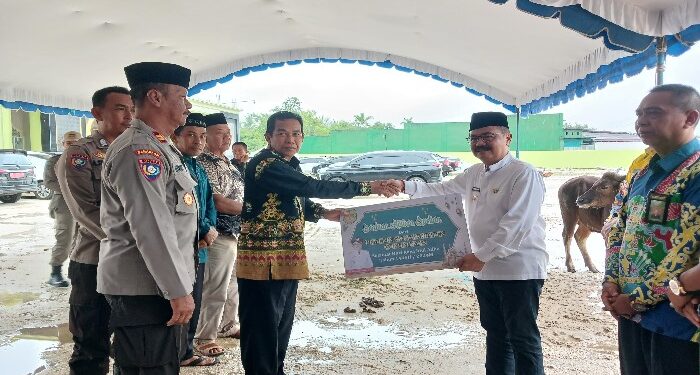 FOTO : DISKOMINFO SANTIK/MATA KALTENG - Pj Bupati Gumas Herson B. Aden menyerahkan bantuan hewan kurban kepada Ketua Dewan Masjid HM Rusdi, di halaman Masjid Agung Darun Najah Kuala Kurun, Kamis, 13 Juni 2024.