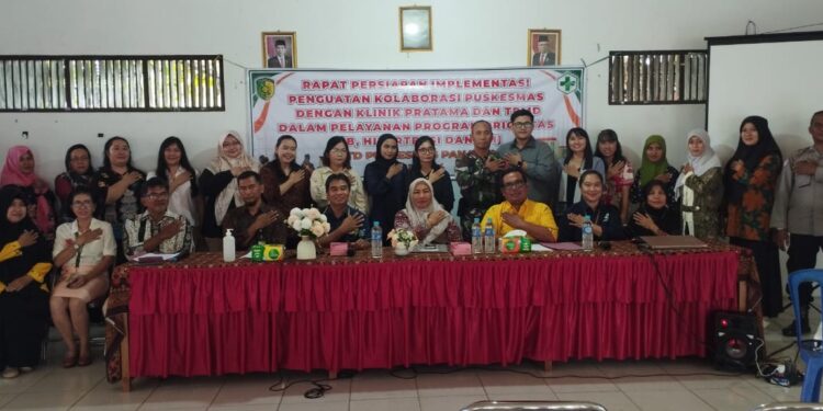 FOTO: RZL/MATAKALTENG - Lurah Panarung Evi Kahayanti saat foto dengan Kasubag TU dan Staff UPT Puskesmas Panarung usai kegiatan rapat.