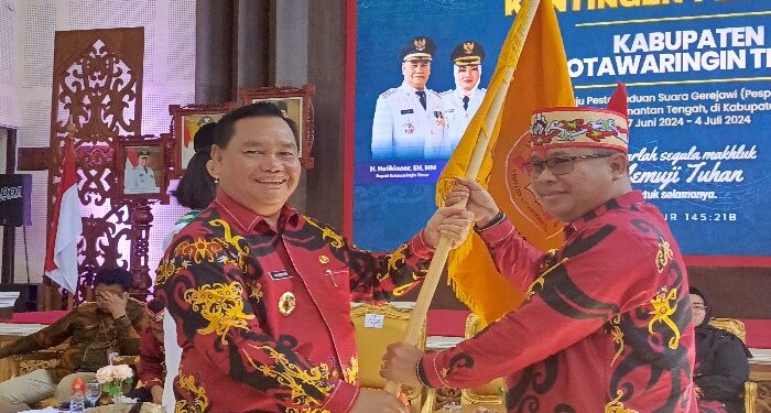 FOTO : DEVIANA/MATAKALTENG - Penyerahan bendera simbol oleh Bupati Kotim Halikinnor kepada Ketua LPDP Kotim Diana Setiawan pelepasan peserta Pesparawi, Kamis 27 Juni 2024.