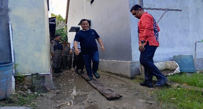 FOTO : DEVIANA/MATAKALTENG - Bupati Kotim Halikinnor saat melintas di atas papan karena kondisi jalan yang tergenang air, Kamis 27 Juni 2024.