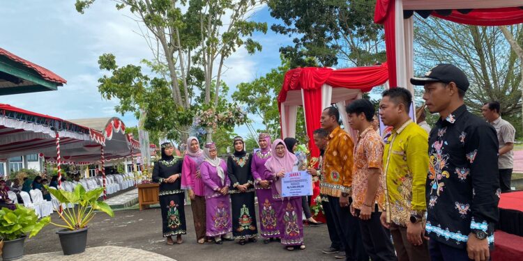Foto : AKH/MATAKALTENG - Pj Bupati Sukamara saat memberikan hadiah kepada pemenang lomba dalam rangka peringatan Hari Jadi ke-22 Kabupaten Sukamara.