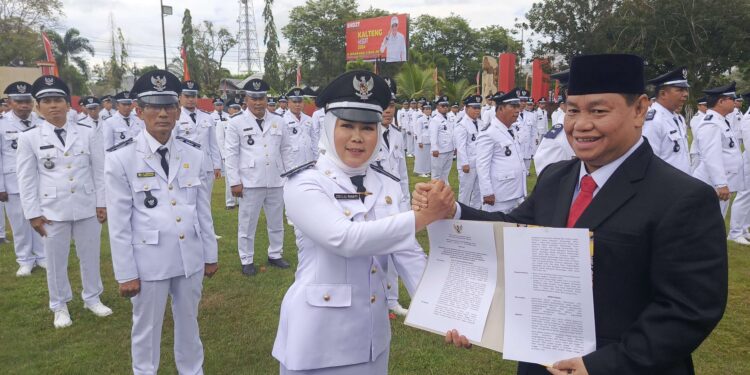 FOTO : DEVIANA/MATAKALTENG - Bupati Kotim Halikinnor saat menyerahkan berita acara kepada salah satu kades, Jumat 5 Juli 2024.