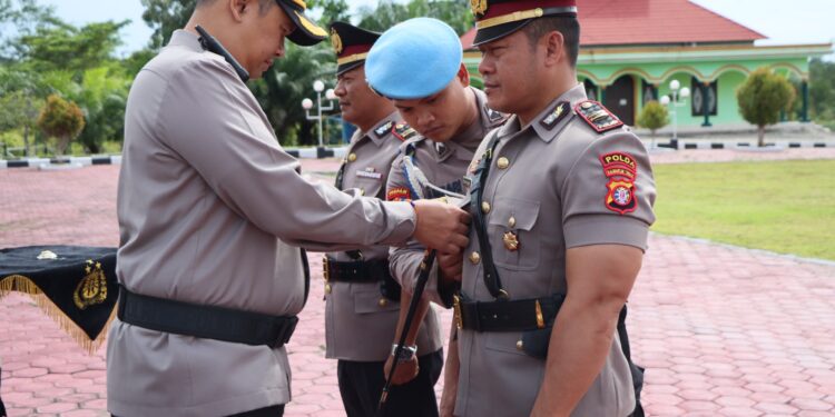FOTO : HUMAS POLRES GUMAS/MATA KALTENG - Kapolres Gumas AKBP Theodorus Priyo Santosa menyematkan tanda pangkat kepada Kapolsek Manuhing, pada kegiatan sertijab di halaman mapolres setempat, Kamis, 11 Juli 2024.