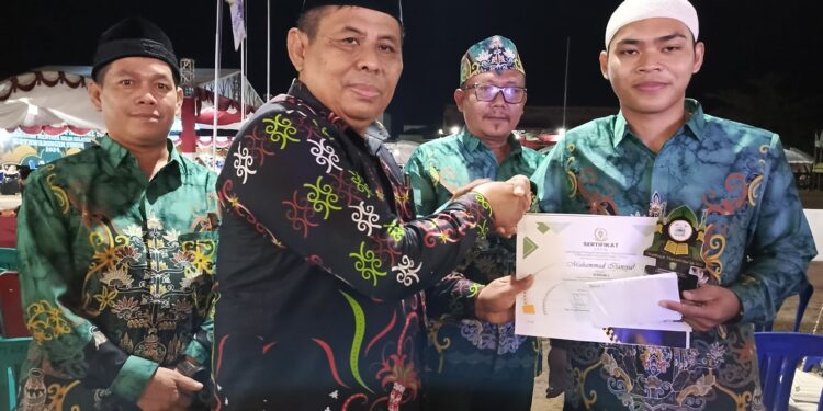 FOTO : DEVIANA/MATAKALTENG - Camat Tualan Hulu Admadi Sastra saat menyerahkan piagam dan bonus kepada kafilahnya, Kamis 11 Juli 2024.