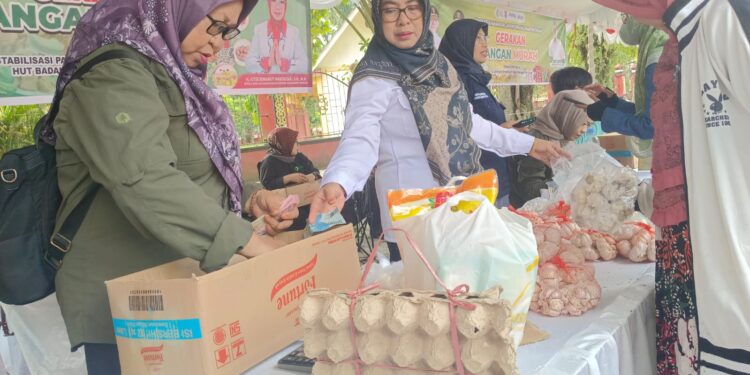 FOTO : DEVIANA/MATAKALTENG - Kepala DKPP Kotim Sepnita saat membantu di pasar pangan murah, Rabu 24 Juli 2024.