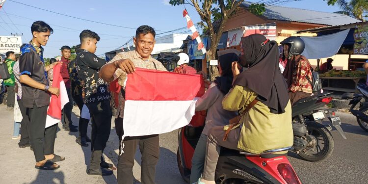 FOTO : DEVIANA/MATAKALTENG - Pembagian bendera merah putih secara gratis di Pasar Al-Kamal, Kamis 25 Juli 2024.