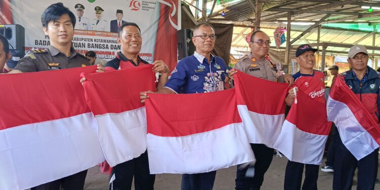 FOTO ; DEVIANA/MATAKALTENG - Kepala Kesbangpol Kotim Sanggul Lumban Gaol bersama lainnya saat pembagian bendera merah putih, belum lama ini.