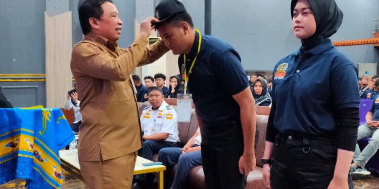 FOTO : IST/MATAKALTENG - Sekda Kotim Fajrurrahman saat memasangkan tpi kepada peserta menandakan diklat pemberdayaan masyarakat dibuka, Selasa 30 Juli 2024.