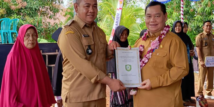 FOTO : DEVIANA/MATAKALTENG - Bupati Kotim Halikinnor saat menerima SKT dari Kades Rastum terkait hibah tanah, Senin 5 Agustus 2024.