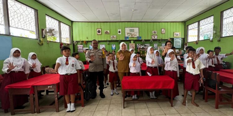 FOTO: RZL/MATAKALTENG - Lurah Panarung, Evi Kahayanti, bersama Bhabinkamtibmas, Aiptu Edy Prayitno saat menggelar sosialisasi Anti-Bullying dan Kesadaran Jajanan Sehat di SDN1 Panarung.