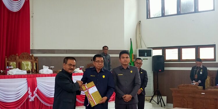 FOTO : DISKOMINFO SANTIK/MATA KALTENG - Pj Bupati Gumas Herson B Aden ketika menyerahkan dokumen Raperda Perubahan APBD tahun 2024 yang sudah ditandatangani, kepada Ketua DPRD Akerman Sahidar dan Wakil Ketua I DPRD Binartha, Selasa, 6 Agustus 2024.