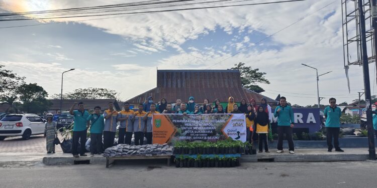 Foto : IST/MATAKALTENG - DLH Kabupaten Sukamara saat membagikan pupuk kompos kepada masyarakat yang ada di Pasar Saik.