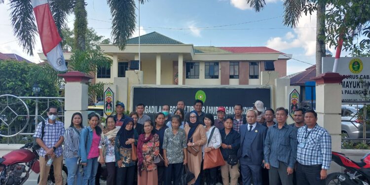 FOTO: RZL/MATAKALTENG - Ahli waris Dambung Djaya Angin saat berfoto di depan Pengadilan Negeri Palangka Raya, usai menghadiri sidang.