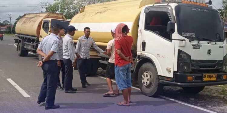 FOTO : IST/MATAKALTENG - Anggota Dishub Kotim saat menegur sopir angkutan CPO yang melintas di Jalan Kota Sampit, belum lama ini.