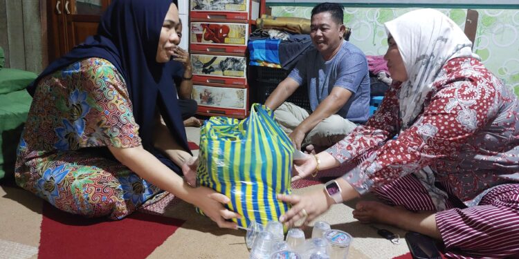 FOTO: RZL/MATAKALTENG - Lurah Panarung, Evi Kahayanti (kanan), saat mengunjungi dan menyerahkan bantuan kepada korban dugaan TPPO, Ria Hidayah (kiri).