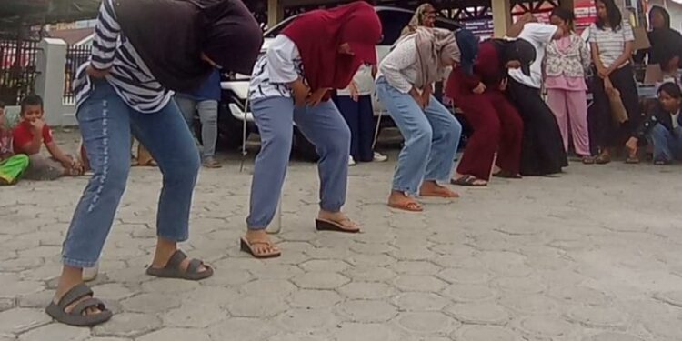 FOTO: RZL/MATAKALTENG - Warga Kelurahan Langkai, saat mengikuti lomba memasukkan paku ke dalam botol.